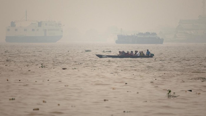 A drone view of people riding a wooden boat crossing the Kapuas river as haze from wildfires blankets the area in Pontianak, West Kalimantan province, Indonesia, August 27, 2026. REUTERS/Willy Kurniawan