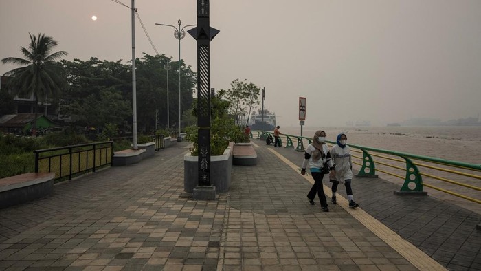 A drone view of people riding a wooden boat crossing the Kapuas river as haze from wildfires blankets the area in Pontianak, West Kalimantan province, Indonesia, August 27, 2026. REUTERS/Willy Kurniawan