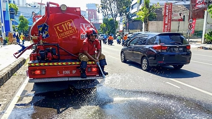 Mobil Damkar menyiram jalan di Surabaya