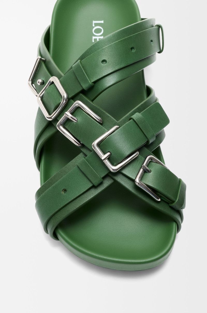 Sandal Loewe Viral Rumah mode asal Spanyol ini menghadirkan sandal yang menjadikan nama brand sebagai bagian dari desain melalui deretan buckle logam berukuran besar.