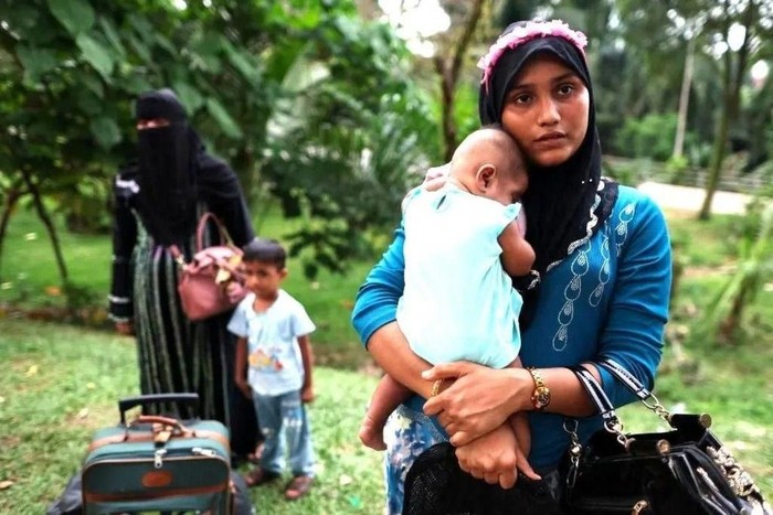 Para perempuan dan anak-anak mereka ini termasuk di antara pengungsi Rohingya yang diusir dari rumah mereka di Malaysia (Reuters)
