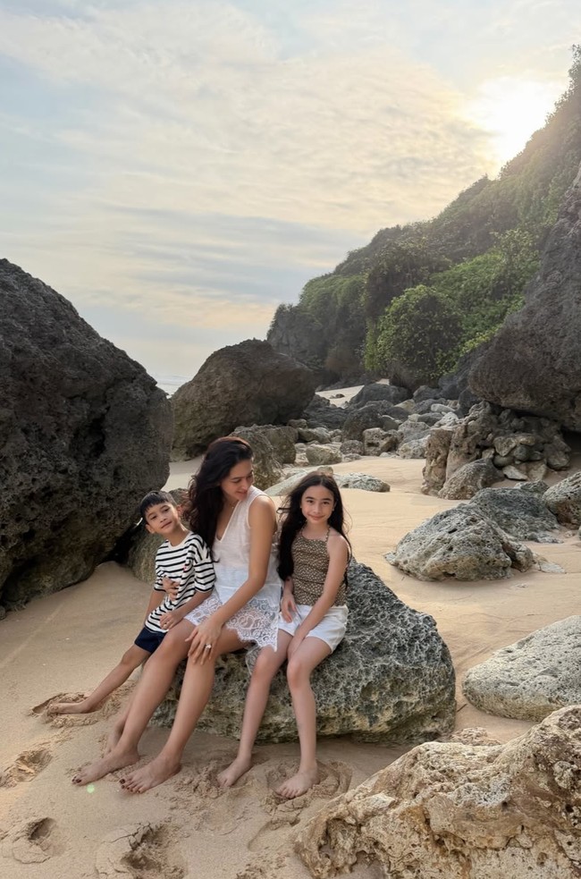 Bermain di pantai, Nabila tampak mengenakan busana berwarna putih tipis tanpa lengan dengan detail lace pada bagian bawahnya. Rambut panjangnya tampak dibiarkan terurai natural. Foto: Instagram/@nsyakieb85