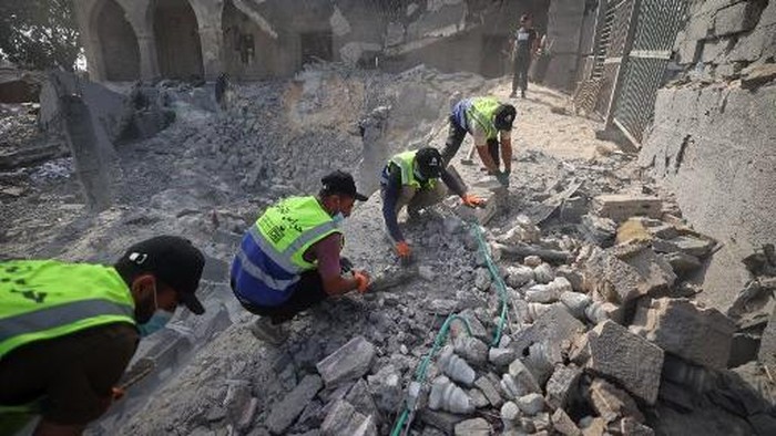 Volunteers from the Guardians of Heritage team carry out conservation work as part of an initiative to protect the historical features of the damaged Abu Salim mosque that was recently hit by an Israeli strike in Deir el-Balah, central Gaza Strip o