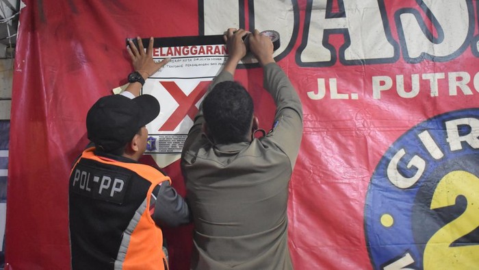 Satpol PP Surabaya menindak warkop di Rangkah yang menjual miras tanpa izin dan menggelar karaoke hingga mengganggu warga.