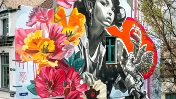 EVE, Lula Goce. Mural di Ostend, Belgia, menampilkan sosok perempuan bergaya monokrom yang dikelilingi bunga dan lanskap pesisir, dengan lingkaran merah-oranye sebagai titik perhatian. Foto: Street Art Utopia