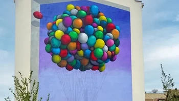 L’invitation au voyage, SETH. Mural SETH di Paris, Prancis menggambarkan seorang anak yang berayun di bawah kumpulan balon warna-warni, menciptakan kesan seperti sedang terbang menuju petualangan. Foto: Street Art Utopia