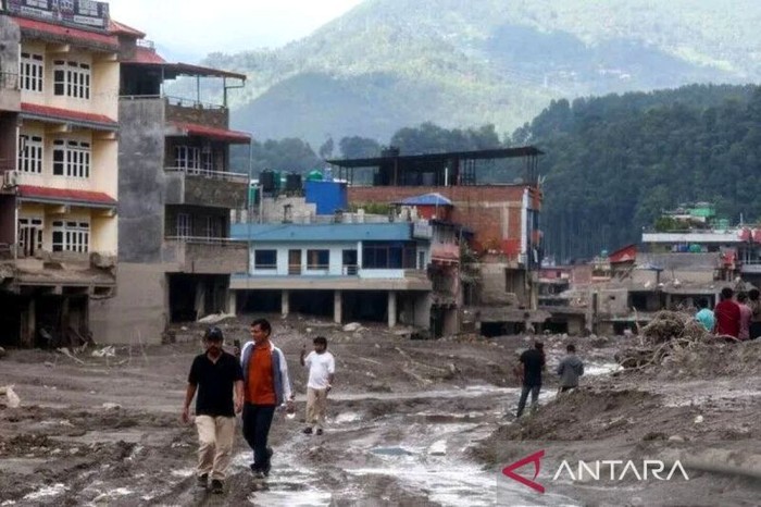 Warga berjalan di tengah lumpur dan puing-puing rumah yang runtuh akibat tanah longsor dan banjir bandang di wilayah dekat perbatasan Nepal-Tiongkok, di Nuwakot, Nepal, pada 28 Agustus 2026. ANTARA/Daniel Ceng - Anadolu Agency /pri.