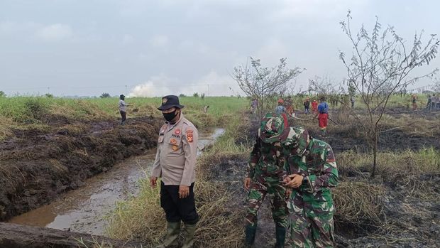 Personel gabungan Polri-TNI berjibaku memadamkan kebakaran di Pangkalan Kerinci, Pelalawan, Riau, Sabtu (29/8/2026).