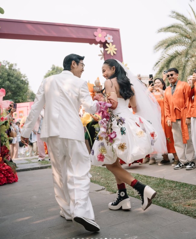 Sementara Pila tampil dengan mini dress putih dihiasi aplikasi bunga 3D warna-warni. Penampilannya semakin lengkap dengan sarung tangan transparan panjang warna merah marun yang senada dengan anting serta warna batu pada kalung emas yang dikenakannya. Foto: Instagram/@aulion