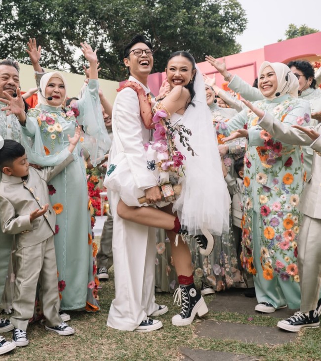 Motif floral juga terlihat pada busana seragam keluarga. Didominasi warna hijau pastel, busana keluarga tersebut dipercantik dengan bordiran bunga warna-warni. Foto: Instagram/@aulion