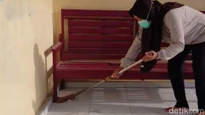 Desi Ratnasari, warga Kotawaringin Barat, saat menyapu rumah yang penuh debu karhutla