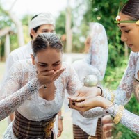 Wanita 43 tahun itu tampak serius mengikuti rangkaian prosesi upacara adat. Sang suami, Maxime Bouttier yang berdiri di belakang Luna Maya juga tampak setia mendampingi istrinya. Foto: Instagram/@lunamaya