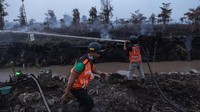 Petugas berjibaku memadamkan kebakaran hutan dan lahan yang melanda sejumlah wilayah di Kalimantan. Api membakar kawasan gambut hingga perkebunan kelapa sawit dan terus mengancam area di sekitarnya. Foto: REUTERS/Willy Kurniawan
