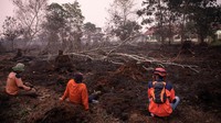 Petugas pemadam harus masuk ke area terbakar untuk menyemprotkan air dan mengendalikan api. Di sejumlah lokasi, warga turut membantu memadamkan api yang membakar lahan perkebunan mereka. Foto: REUTERS/Willy Kurniawan