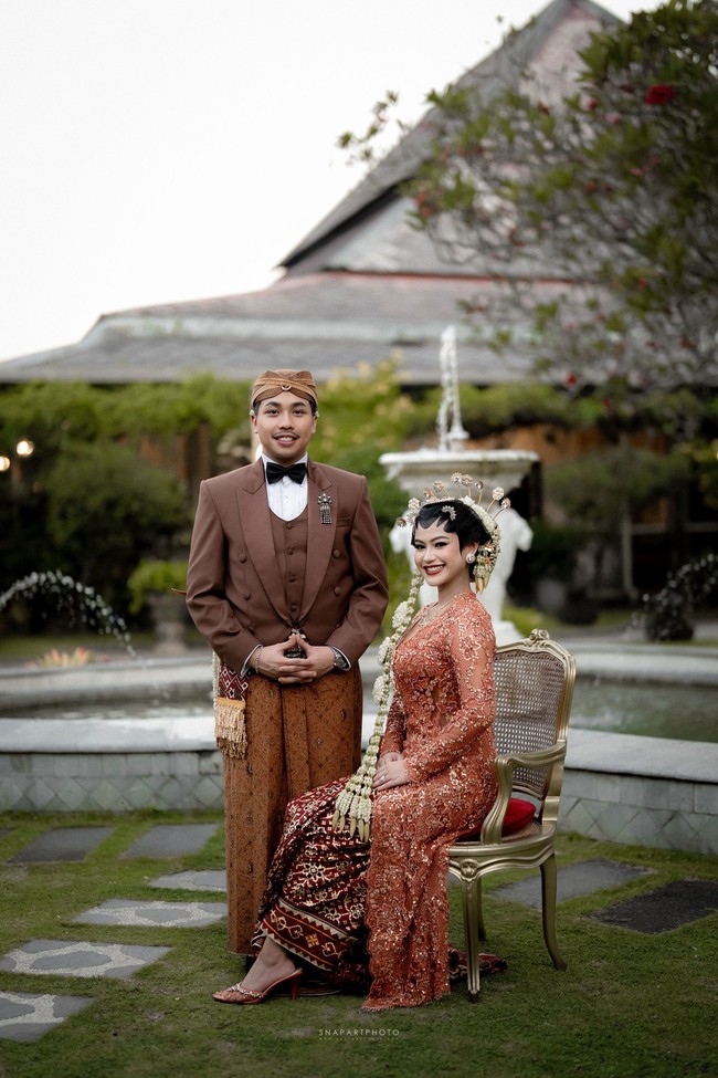 Untuk momen istimewa Tunku Aishah, Didiet mempersembahkan kebaya kutubaru panjang yang hadir dalam warna coral dengan panel tengah yang mempertahankan siluet klasik. Tampilan kebaya yang dibuat di bawah label Svarna IKAT Indonesia ini kemudian diperkuat dengan detail payet kristal tiga dimensi. (Foto: Dok. Instagram/@snapartphoto @dewannanda)