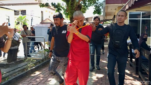 Polisi gadungan berinisial BDSP yang melakukan pemerasan digelandang petugas ke ruang tahanan Polda NTB, Senin (31/8/2026). (Foto: Abdurrasyid Efendi/detikBali)
