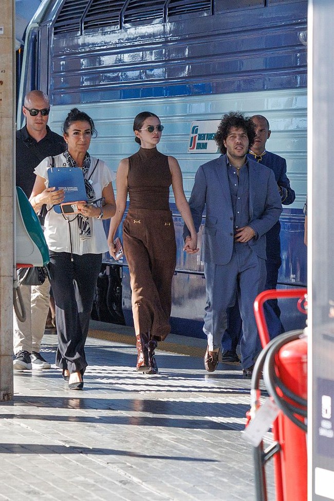Setelah turun dari kereta Orient Express di stasiun Santa Lucia, pasangan musisi ini berjalan bergandengan tangan menuju taksi air yang sudah menunggu di dekat stasiun. Foto: Getty Images/Stefano Mazzola