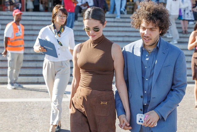 Selena memilih gaya bernuansa cokelat yang cocok dengan suasana akhir musim panas menuju musim gugur. Penyanyi “I Said I Love You First” itu mengenakan blus tanpa lengan dan rok suede kecokelatan. Selena melengkapi penampilan dengan kacamata hitam model aviator dan anting berlian. Foto: Getty Images/Stefano Mazzola