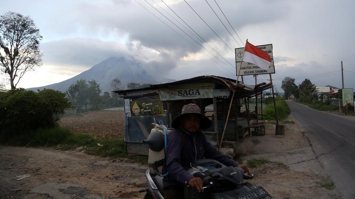 Warga mengendarai sepeda motor dengan latar Gunung Sinabung yang erupsi di Kecamatan Naman Teran, Kabupaten Karo, Sumatera Utara, Senin (31/8/2026). Gunung Sinabung mengalami erupsi dengan tinggi kolom abu mencapai 3.500 meter atau sekitar 5.960 meter di atas permukaan laut.ANTARA FOTO/Yudi Manar