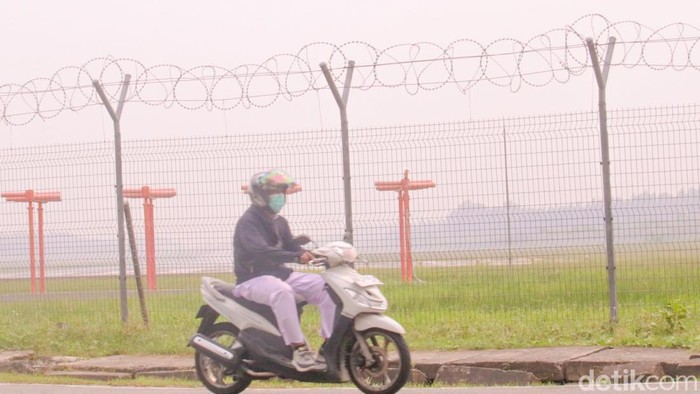 Warga menggunakan masker saat melintas di depan perimeter Bandara Juwata Tarakan, Jalan Aki Balak, Tarakan Barat, Senin (31/8).