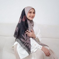 Gaya feminin ala Nadzira terlihat manis lewat paduan atasan putih dan hijab bermotif bunga bernuansa gading serta cokelat pastel. Rok plisket bernuansa senada melengkapi penampilannya yang memberikan kesan lembut dan bersahaja. Foto: Dok. Instagram @enazirashf_.