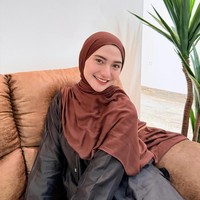 Paduan santai terpancar dari pilihan kemeja berpotongan longgar warna gelap yang dipadukan dengan pashmina cokelat. Lilitan hijab pashmina yang simpel memberikan kesan effortless yang nyaman dipakai sehari-hari. Foto: Dok. Instagram @enazirashf_.