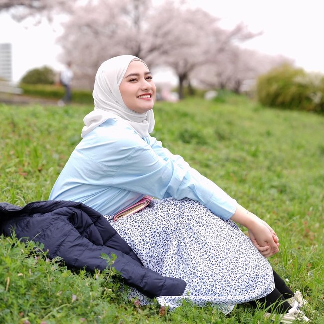 Gaya kasual yang segar ditunjukkan wanita 26 tahun ini lewat kemeja biru muda bertumpuk puffer jacket dan rok bermotif floral kecil. Pilihan hijab pashmina putih yang dililit rapi membuat tampilan luar ruangannya terlihat santai sekaligus manis. Foto: Dok. Instagram @enazirashf_.