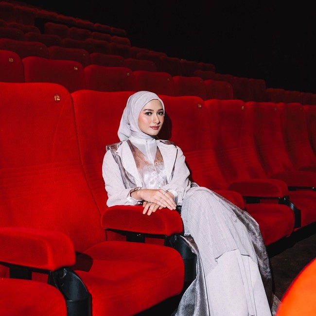 Gaya formal terpancarkan lewat perpaduan gaun bernuansa perak dengan aksen outer transparan yang berkilau. Hijab pashmina dengan lilitan rapi mempertegas tampilan yang anggun dan berkelas di acara malam. Foto: Dok. Instagram @enazirashf_.