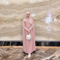 Nadzira mengenakan cape dress berwarna dusty pink yang memberikan siluet anggun dan memesona. Dipadukan dengan hijab simpel bernuansa senada serta tas tangan putih, tampilannya terlihat mewah namun tetap santun. Foto: Dok. Instagram @enazirashf_.
