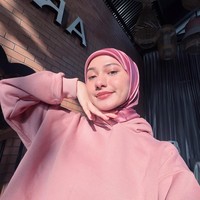 Gaya santai ala streetwear ditampilkan lewat perpaduan hoodie merah muda dengan hijab segi empat bahan satin bernuansa senada. Efek kilap dari hijab satin memberikan sentuhan manis dan trendi pada pakaian kasualnya. Foto: Dok. Instagram @enazirashf_.