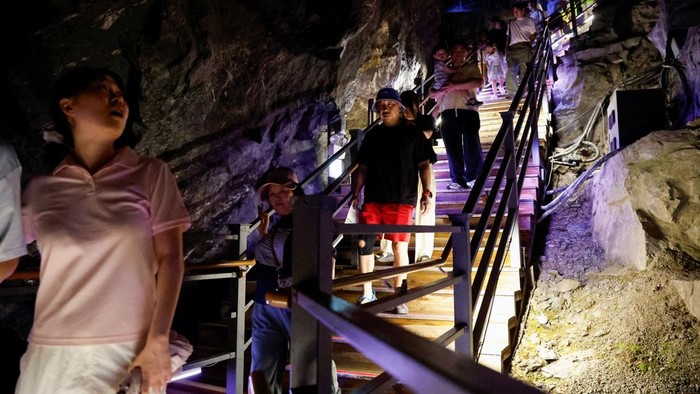 Visitors look at an illuminated installation inside Gwangmyeong Cave, a former gold mine turned into a tourist attraction, during a record-breaking heatwave in Gwangmyeong, South Korea, August 5, 2026, after Yangsan recorded the highest temperature in the country in 122 years of weather observations on Sunday. REUTERS/Kim Soo-hyeon