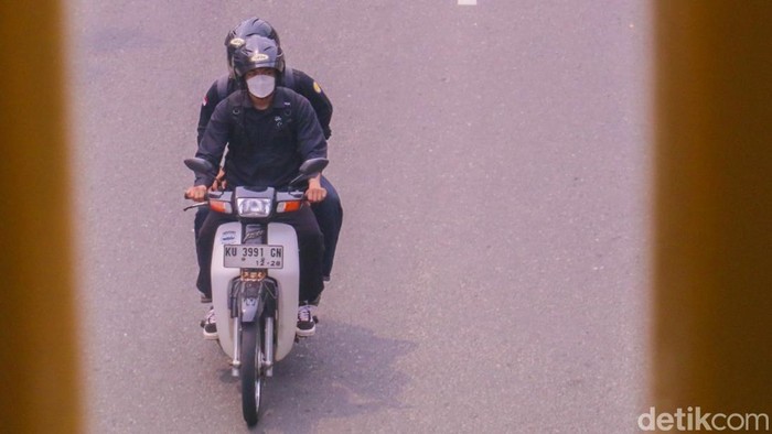Pengendara sepeda motor yang melintas di Jalan Jenderal Sudirman, Tarakan Barat, terlihat mengenakan masker untuk melindungi diri dari paparan kabut asap yang menyelimuti kota pada Selasa (1/9/2026). (0ktavian Balang/detikKalimantan)