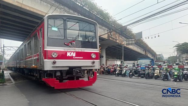 Sejumlah kendaraan menunggu di belakang palang pintu perlintasan Kereta Api saat Kereta Rel Listrik (KRL) Commuter Line melintasi di dekat Stasiun Karet, Jakarta, Selasa (1/9/2026). (CNBC Indonesia/Ferry Sandi)