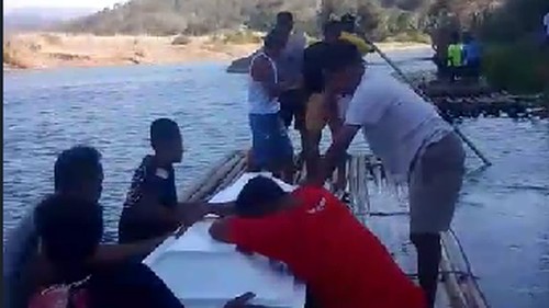 Jenazah perempuan inisial ST diangkut menggunakan rakit bambu untuk menyeberangi sungai menuju rumah duka di Manggarai Timur, NTT, Minggu (30/8/2026). (Tangkapan layar video viral)