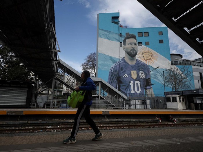 A commuter walks past a mural of Argentine soccer legend Lionel Messi, on the day he announced his retirement from the national team, at the Villa del Parque train station, in Buenos Aires, Argentina, August 31, 2026. REUTERS/Agustin Marcarian