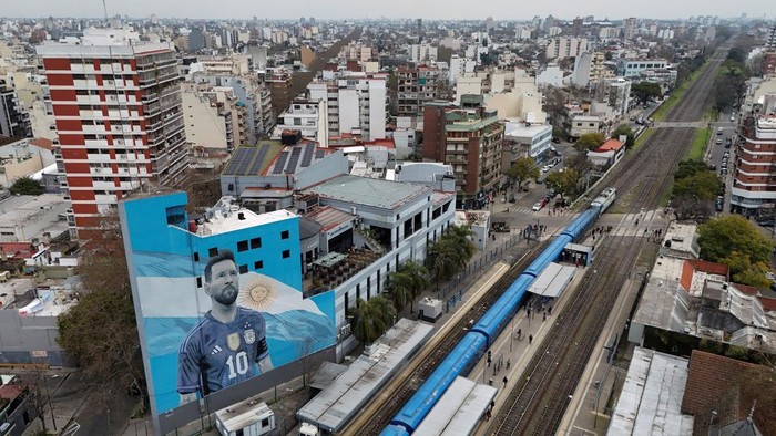 A commuter walks past a mural of Argentine soccer legend Lionel Messi, on the day he announced his retirement from the national team, at the Villa del Parque train station, in Buenos Aires, Argentina, August 31, 2026. REUTERS/Agustin Marcarian