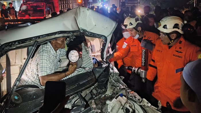 Petugas saat mengevakuasi pasutri  terjepit di Grand Max usai tabrak truk di Lampung