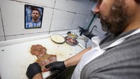 Chef Damian Zanotti mengolah milanesa, makanan khas Argentina, menjadi potret wajah Lionel Messi di restoran El Antojo, Buenos Aires, kemarin. REUTERS/Agustin Marcarian