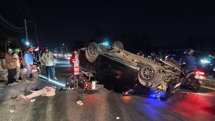 Toyota Agya terbalik usai menerabas pembatas jalan hingga lompat ke jalur berlawanan. Nahas, mobil ini menabrak pemotor yang berboncengan.