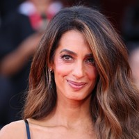 Pengacara hak asasi manusia kelahiran Lebanon ini tampil dengan gaya riasan khasnya dan membiarkan rambut cokelat panjangnya terurai. Rambutnya ditata dengan belahan samping dan gelombang, menciptakan tampilan Oly Hollywood.Foto: Dok. Getty Images, AFP