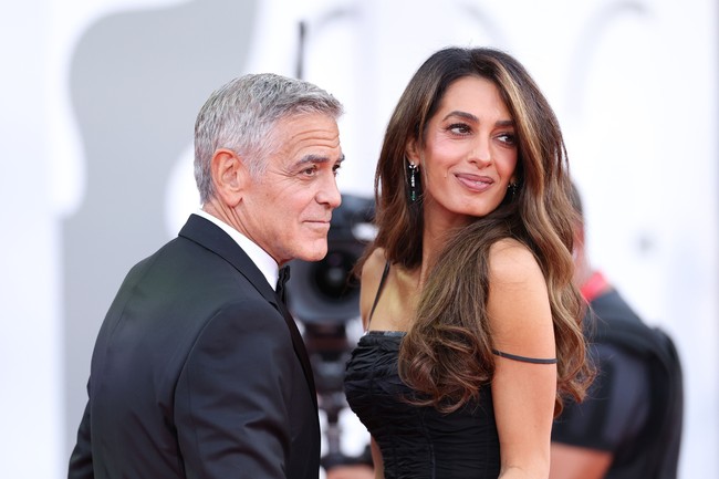 George Clooney sendiri tampil serasi dengan Amal Clooney memakai tuksedo hitam, kemeja putih dan dasi kupu-kupu. Pada ajang Festival Film Venesia 2026, bintang film Ocean’s Eleven itu menerima penghargaan Golden Lion for Lifetime Achievement. Foto: Dok. Getty Images, AFP