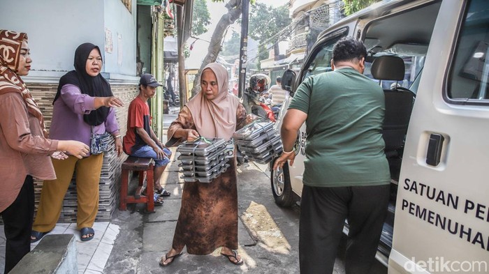 Sejumlah warga memberikan Makan Bergizi Gratis untuk golongan bumil, busui dan balita di Kalibaru, Cilincing, Jakarta Utara, Kamis (3/9/2026).