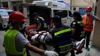 Tim tanggap darurat melakukan simulasi evakuasi korban dalam latihan penembak aktif di sekolah Filipina. Petugas juga berlatih mengangkut korban menggunakan ambulans. REUTERS/Eloisa Lopez