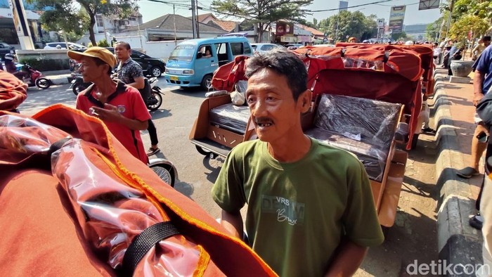 Amin, salah seorang pengemudi becak yang mendapat bantuan becak listrik