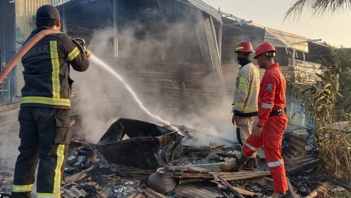 Petugas damkar memadamkan api di sebuah warung milik warga di Kandanghaur Indramayu.