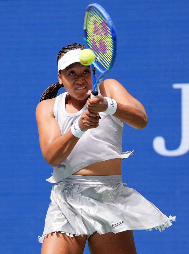 Saat menghadapi petenis Kateřina Siniaková dari Republik Ceko, Naomi melepas trench coat tersebut dan tampil dengan outfit yang lebih praktis untuk bertandingIa mengenakan busana tenis dari Nike yang terdiri tank top dan rok mini pleated dengan lapisan berbahan jaring yang terinspirasi dari baju basket. Nike mengusung basket sebagai tema besar untuk kit para atlet yang disponsorinya. (Foto: IMAGN IMAGES via Reuters/ROBERT DEUTSCH)