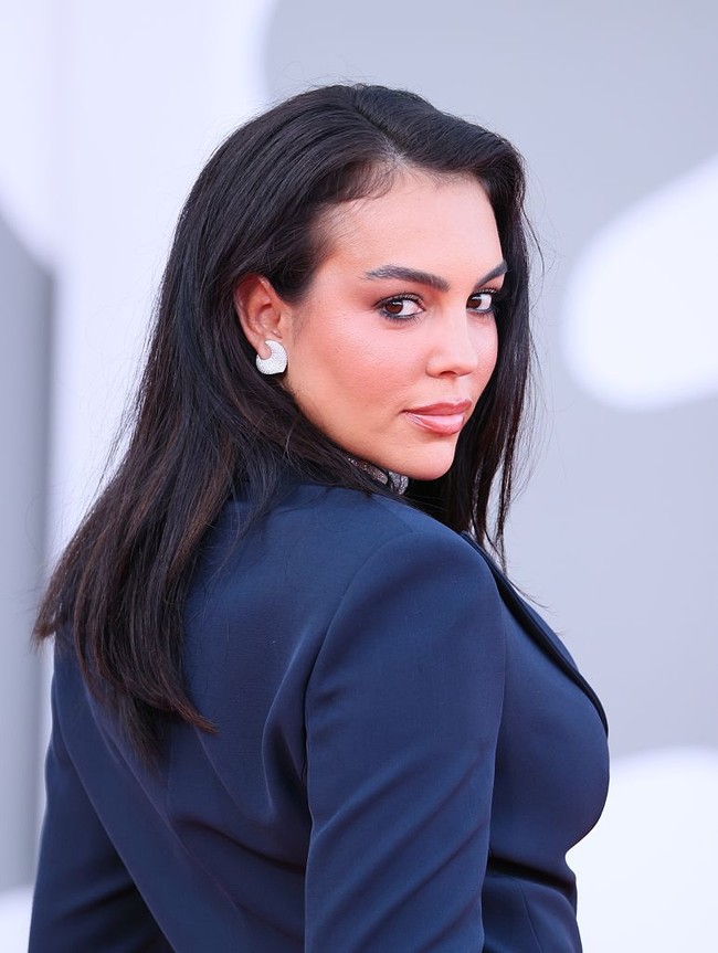 Perpaduan setelan navy yang klasik dengan perhiasan statement membuat penampilan Georgina di red carpet terlihat elegan, tapi di sisi lain juga ultra-glamor. Foto: FilmMagic/JB Lacroix