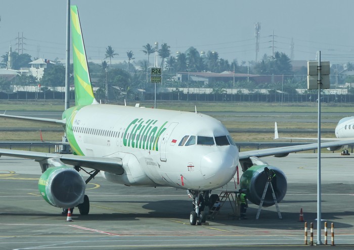 Petugas darat melakukan penutupan mesin pesawat yang terparkir dengan menggunakan bahan khusus di apron Terminal 1 C Bandara Soekarno Hatta, Tangerang, Banten, Minggu (6/9/2026). Penutupan mesin pesawat dilakukan untuk mencegah masuknya sebaran abu vulkanik dari Gunung Anak Krakatau yang mengguyur Bandara Soekarno Hatta. ANTARA FOTO/Muhammad Iqbal/YU