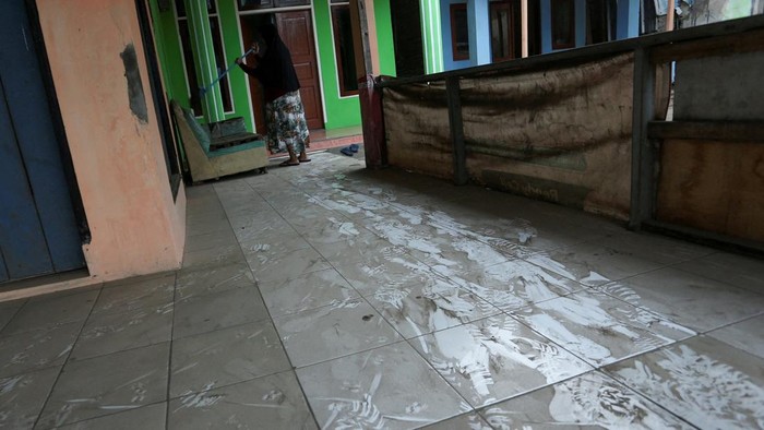 A woman sweeps a floor covered with volcanic ash at Pasauran village, following the Mount Anak Krakatau volcano eruption, in Serang, Banten province, Indonesia, September 6, 2026. REUTERS/Sammy     TPX IMAGES OF THE DAY