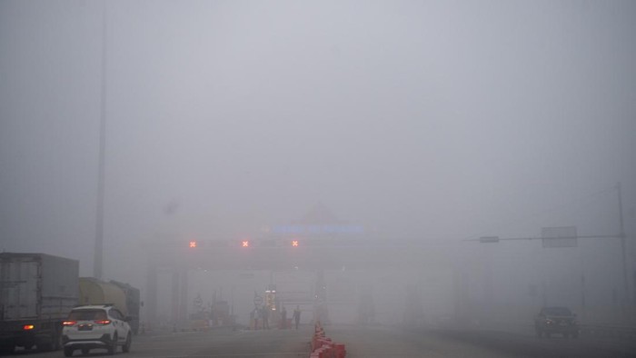 Foto udara sejumlah kendaraan menunggu di gerbang tol Palembang Jalan Tol Trans Sumatera (JTTS) ruas Palembang-Prabumulih yang tertutup kabut asap di Pemulutan, Kabupaten Ogan Ilir (OI), Sumatera Selatan, Minggu (6/9/2026). PT Hutama Karya (Persero) selaku pengelola tol tersebut melakukan penutupan sementara  Jalan Tol Trans Sumatera (JTTS) ruas Palembang-Prabumulih ruas Paelmbang-Prabumulih dikarenakan jarak pandang yang minim akibat kabut asap Kebakaran Lahan dan Hutan (Karhutla). ANTARA FOTO/Nova Wahyudi/YU